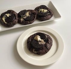 cookies and ice cream are on a plate next to a tray of oreo cookies