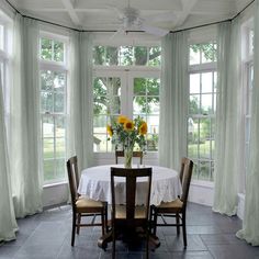 a dining room with blue drapes and sunflowers