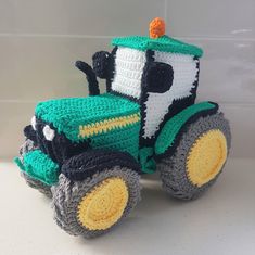 a crocheted toy tractor sitting on top of a white counter next to a tiled wall