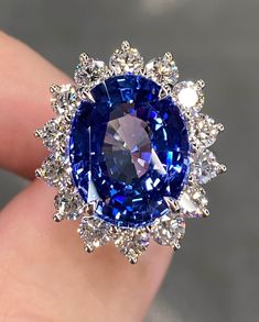 a blue and white diamond ring on someone's finger