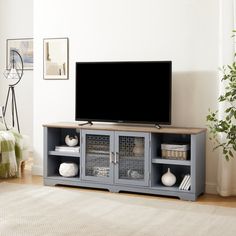 a flat screen tv sitting on top of a wooden entertainment center in a living room