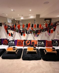 a room with halloween decorations on the walls and black velvet ottomans in front of them