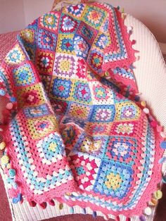 a crocheted blanket sitting on top of a chair