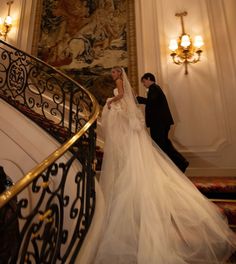 a bride and groom walking down the stairs at their wedding ceremony in an ornate building