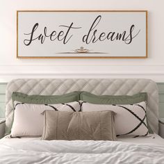 a bedroom with a bed, pillows and a sign above it that says sweet dreams