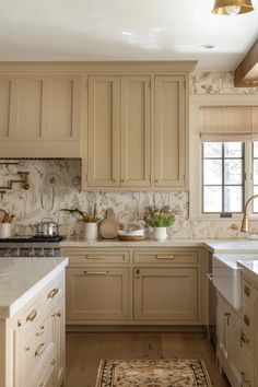 a kitchen with beige cabinets and white counter tops