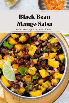 black bean mango salsa in a bowl with limes and cilantro on the side