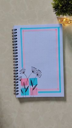 a notebook with flowers on it next to a christmas tree