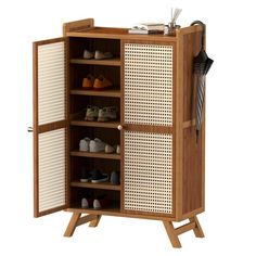 an open wooden cabinet with shoes and umbrellas on the top shelf, in front of a white background