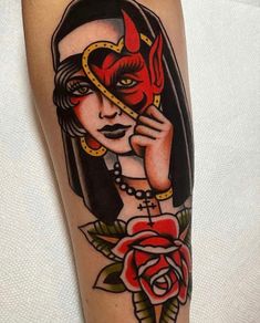 a woman with a devil mask and roses on her arm