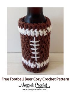 a crocheted beer bottle cozy with a football on the front and white stitching