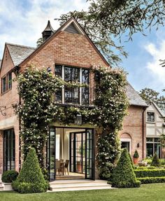 a brick house covered in ivy and flowers