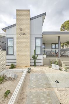 a house with a cactus in front of it and landscaping around the back yard area