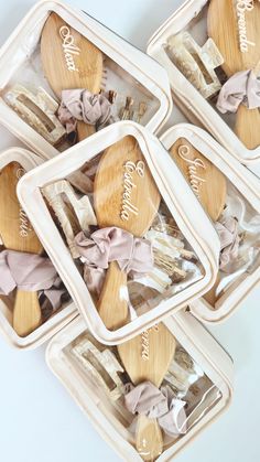 four wooden spoons in plastic containers with bows on them