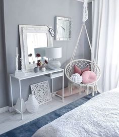 a bedroom with a bed, mirror and hanging chair