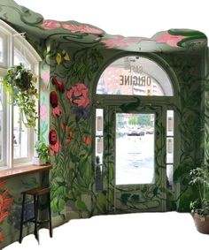 the entrance to an office decorated in green and pink with flowers painted all over it