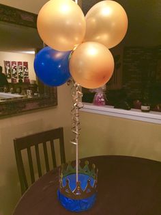 a table with balloons and a crown on it