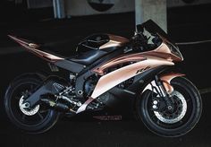 a shiny pink motorcycle parked in a parking lot