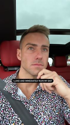 a man sitting in the back seat of a car with his hand on his chin