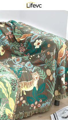 an image of a couch covered with a floral print cover and fringes on it