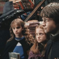 the harry potters are standing next to each other in front of bookshelves