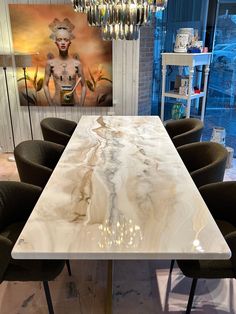 a white marble dining table surrounded by black chairs