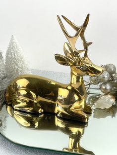 a golden deer statue sitting on top of a glass table