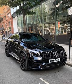 a black mercedes gle is parked on the side of the street