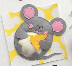 a mouse holding a piece of cheese in it's mouth on a yellow and white background