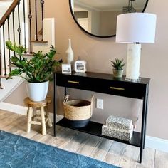 a living room with a blue rug, mirror and plant on the table in front of it