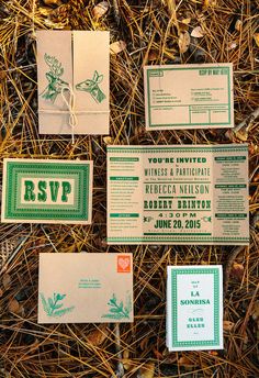 wedding stationery with green and white designs on the front, back and sides are laid out in dry grass