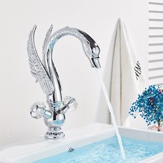 a faucet with water running out of it and blue flowers in the background