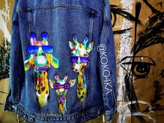 a denim jacket with giraffes painted on it