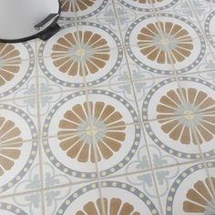 a close up of a tile floor with a bowl on the ground next to it