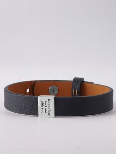 a black leather bracelet with a tag on it