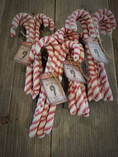 several red and white striped candy canes tied up on wooden planks with price tags