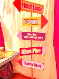 there are many signs on the pole in front of a food cart that says haldii lagao