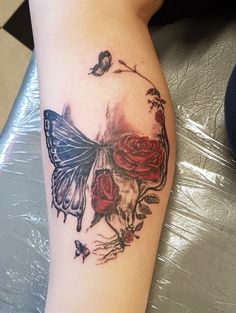 a woman's arm with a skull and roses tattoo on the left side of her leg