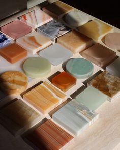 several different types of soaps are arranged on a counter top with various colors and shapes