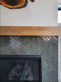 a fire place with a wooden shelf above it