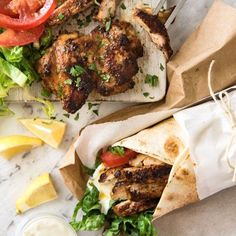 the instagram page shows an image of chicken shawarma with lettuce, tomatoes and lemon wedges