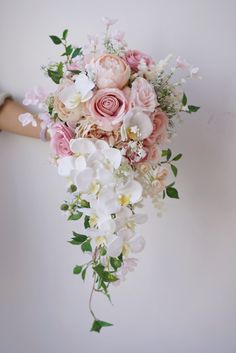 a bridal bouquet with pink and white flowers hanging from it's back end