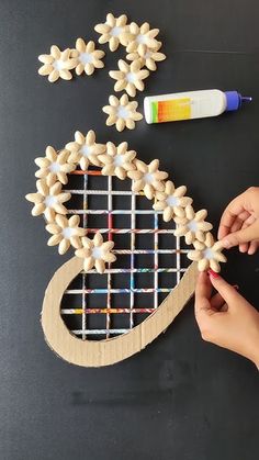 someone is making a tennis racket out of wood and glues it on the table