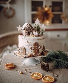 a decorated cake sitting on top of a table next to orange slices and christmas decorations