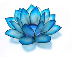 a blue glass flower sitting on top of a white surface