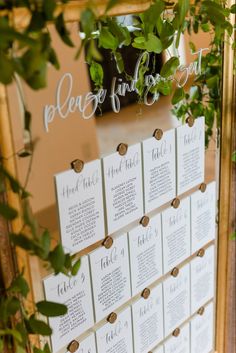 the seating cards were placed on top of each other and hung from a gold framed mirror