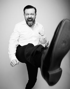 a man sitting on top of a chair with his foot up and mouth wide open