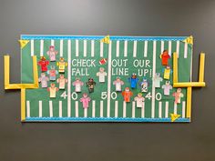 a bulletin board with paper cut out of people and numbers on it, along with the words check out our fall line up