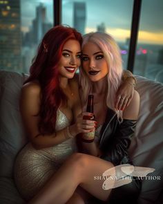 two beautiful women sitting on top of a couch next to each other holding beer bottles