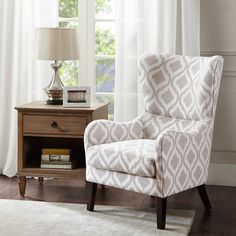 a living room with white curtains and a chair